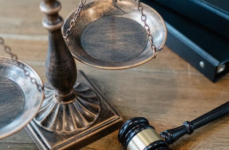 From above of judicial symbols consisting of Scales of Justice and small judge hammer with curly handle