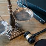 From above of judicial symbols consisting of Scales of Justice and small judge hammer with curly handle